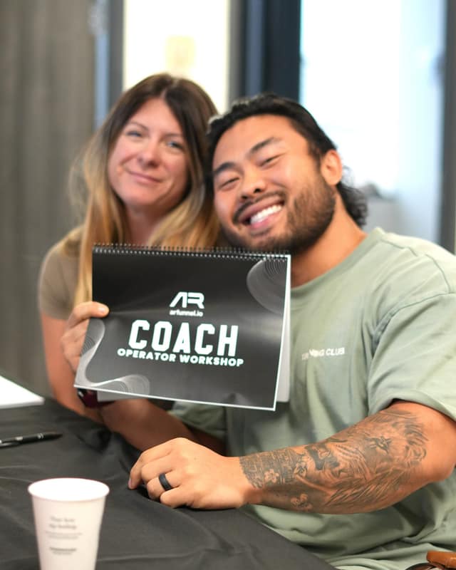 Two coaches holding the Coach Operator Workshop workbook