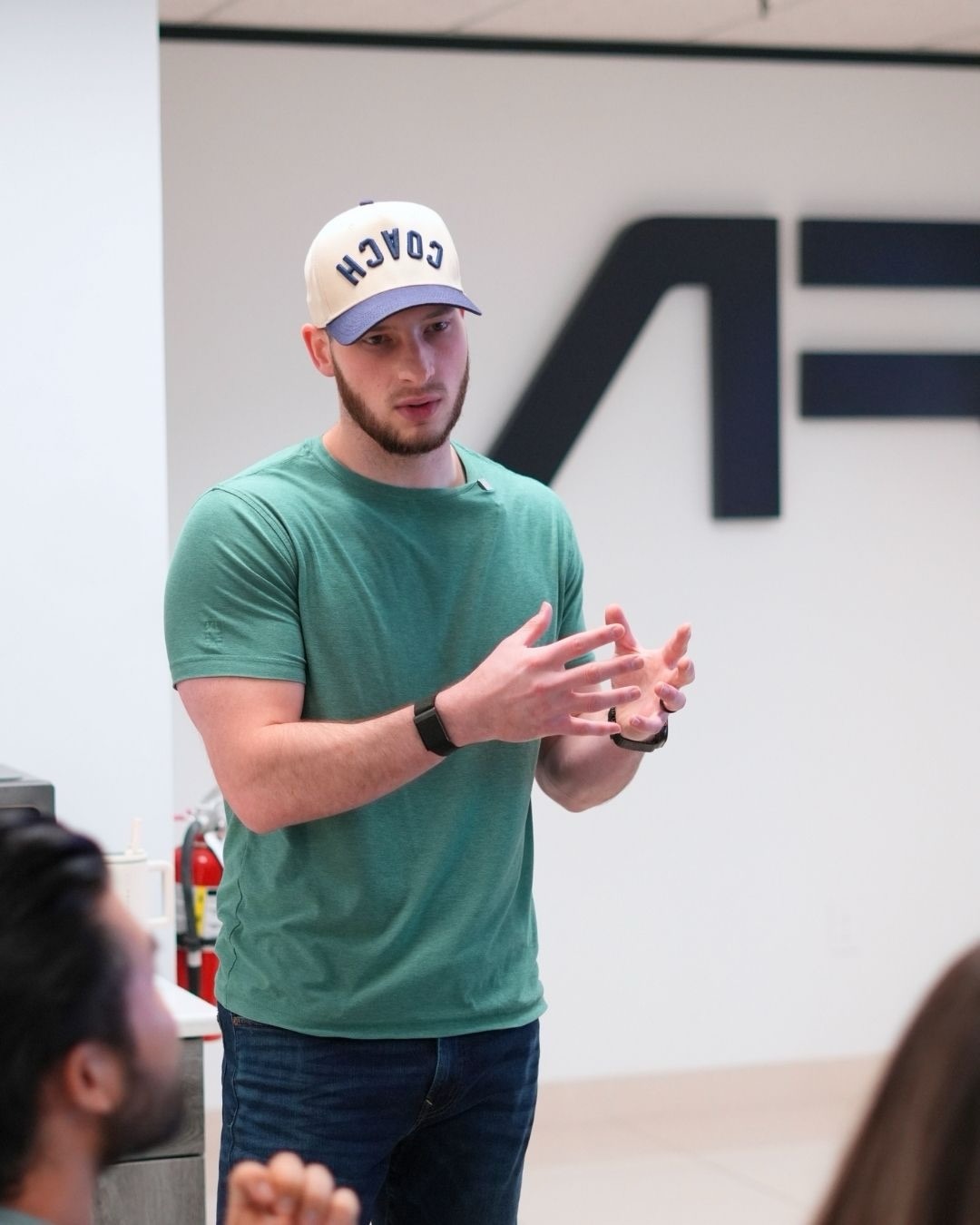 A coach wearing the AR COACH hat