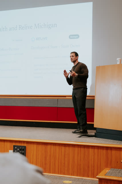 Speaker presenting a client case study slide on stage
