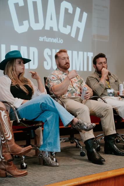 Panelists seated in front of the Lead Summit screen, one answering a question