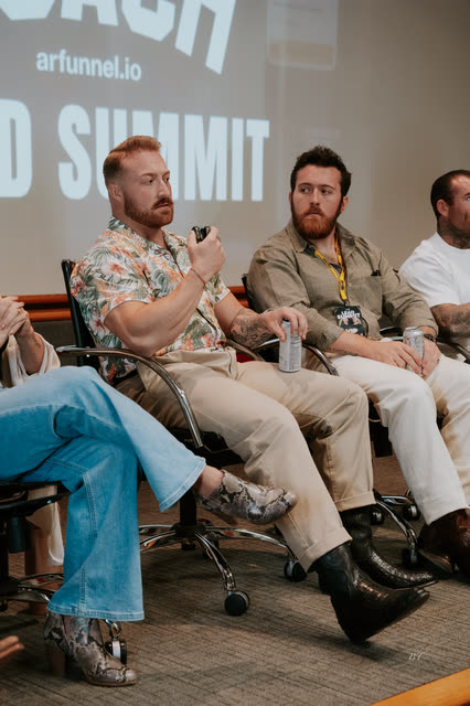 Panelist with a red beard speaking into a microphone