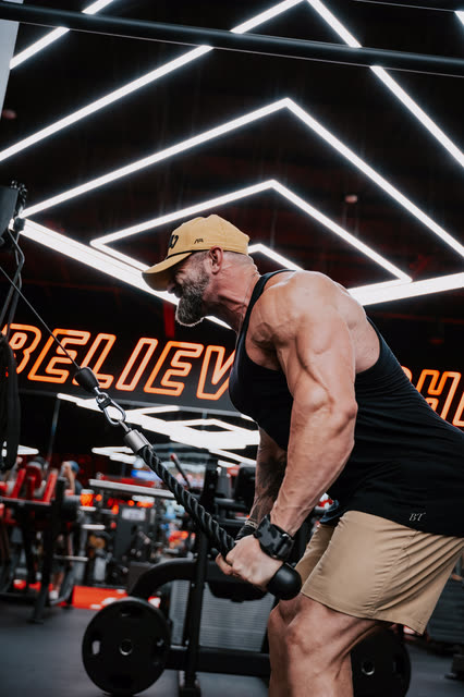 Mike Crowson pulling a rope cable under the Believe neon