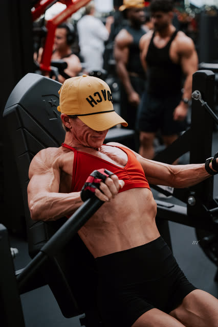 Close up of a coach in a COACH cap mid chest press, face hidden by the brim