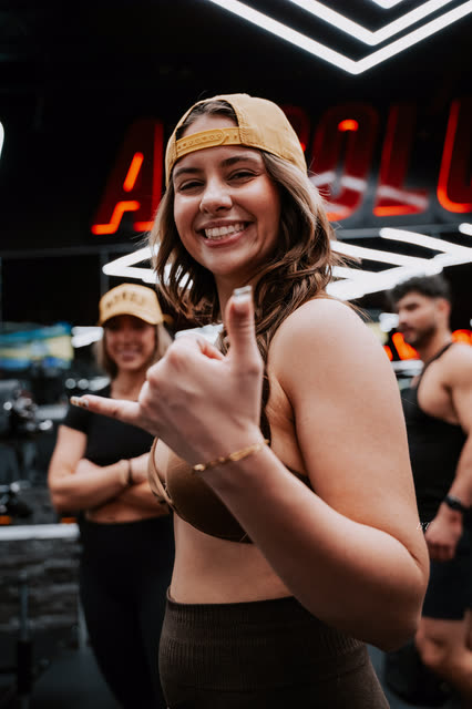 Coach in a backwards COACH cap smiling and giving a thumbs up