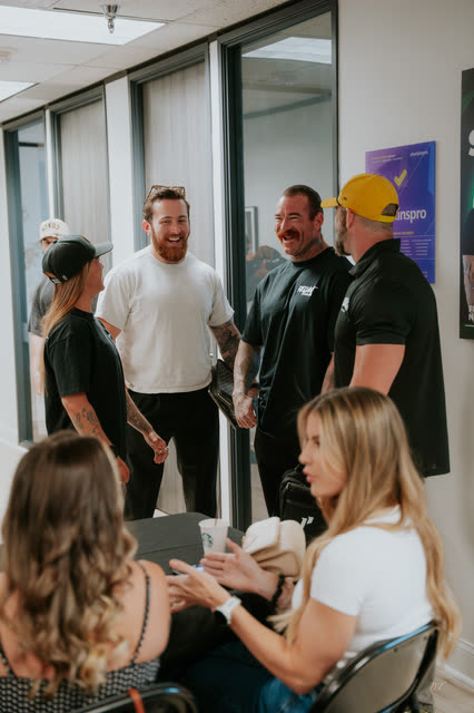 Coaches in COACH gear laughing together in the AR office hallway