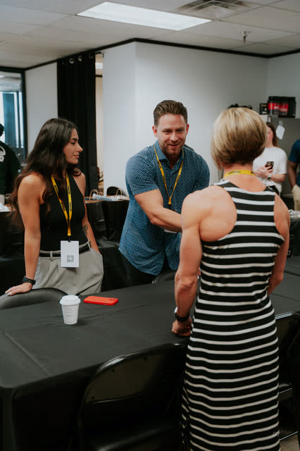 Attendee greeting fellow coaches across the table with a handshake