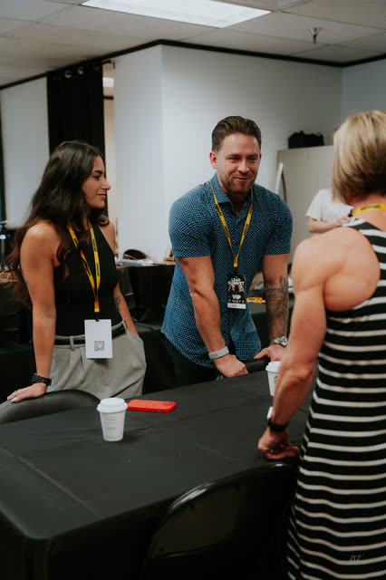 Attendee smiling and greeting fellow coaches across the table