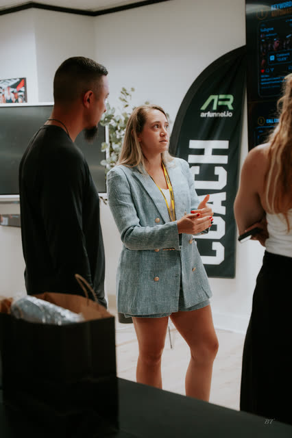 Attendee in a blazer chatting by the AR banner