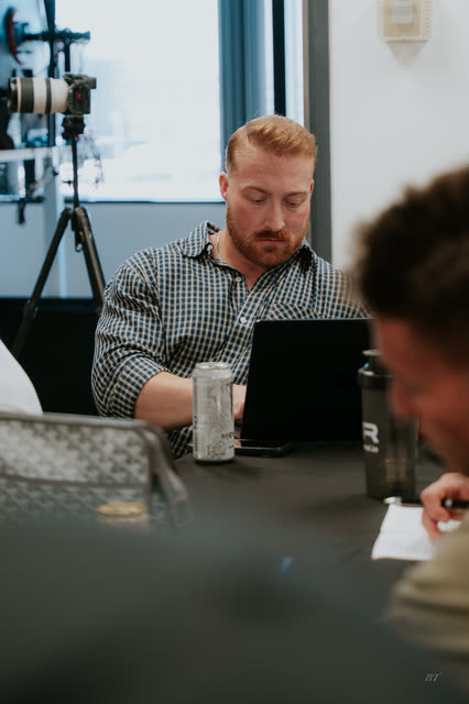 Attendee in a plaid shirt working on his laptop during the VIP breakout