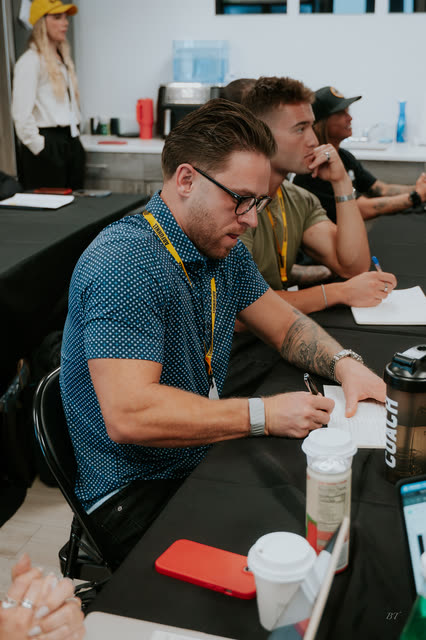 Attendee in glasses taking notes at the VIP breakout table