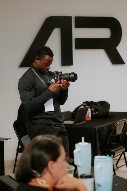 Event photographer shooting in front of the AR logo wall