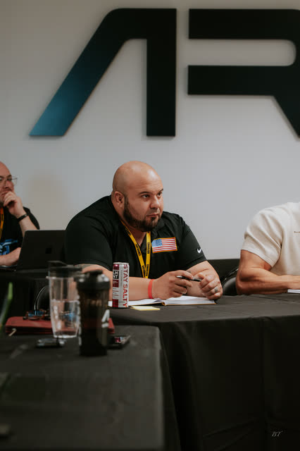 Attendee listening at the breakout table under the AR logo