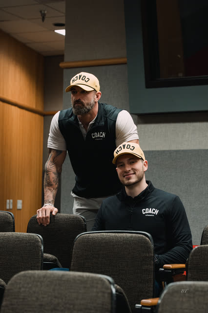 Mike Crowson leaning over Bakker Shields in the lecture hall seats