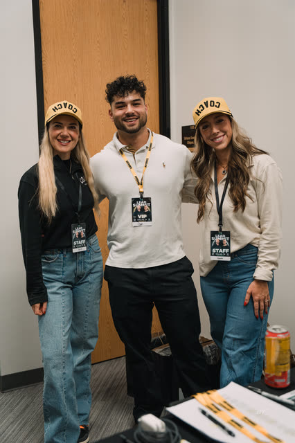Coach in a VIP badge posing with two AR staff in COACH caps