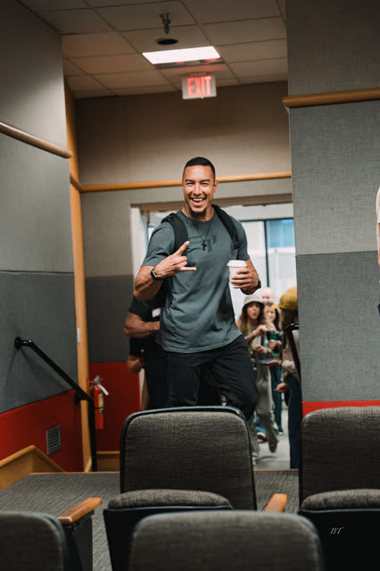 Coach throwing a hang loose sign as he walks into the hall