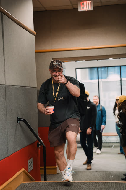 Coach pointing at the camera as he walks into the hall