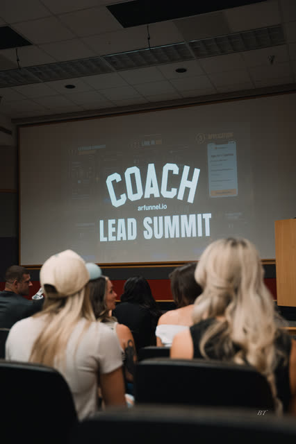 Attendees taking their seats under the COACH Lead Summit screen