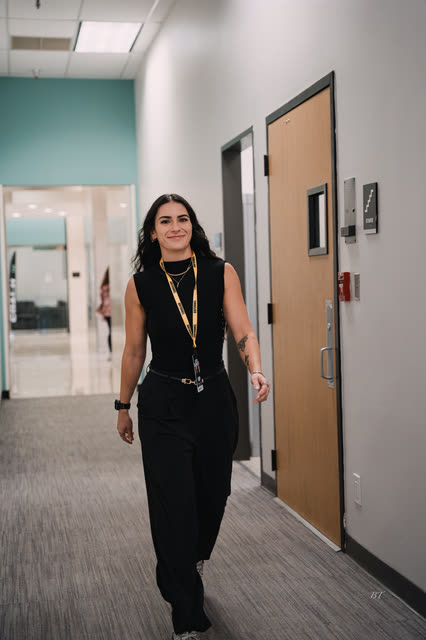 AR staff member in black walking down the hallway